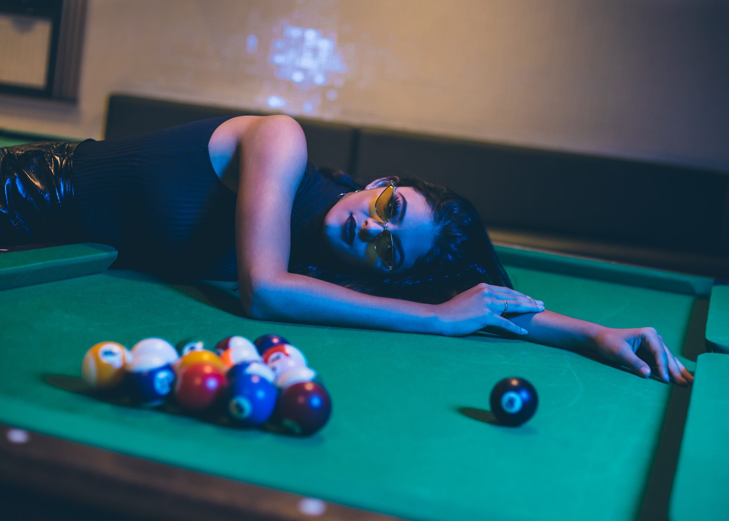 woman laying on pool table