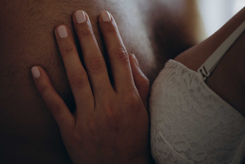 Woman Wearing White Bra Holding Man's Chest