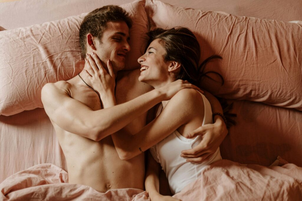 Close-Up Shot of a Swinger Couple Lying Down on the Bed Together
