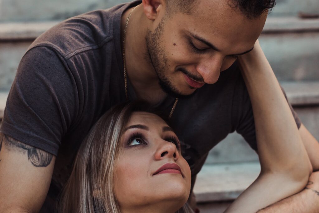 Woman Sitting in Between Man's Legs Looking Up