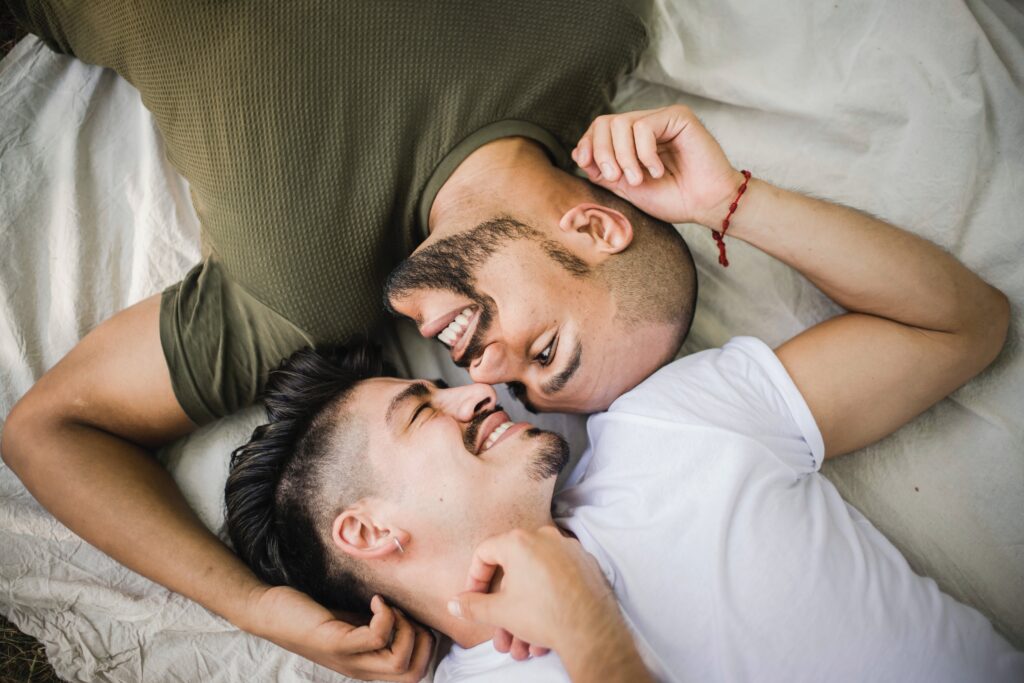 Men Lying on Bed While Looking at Each Other