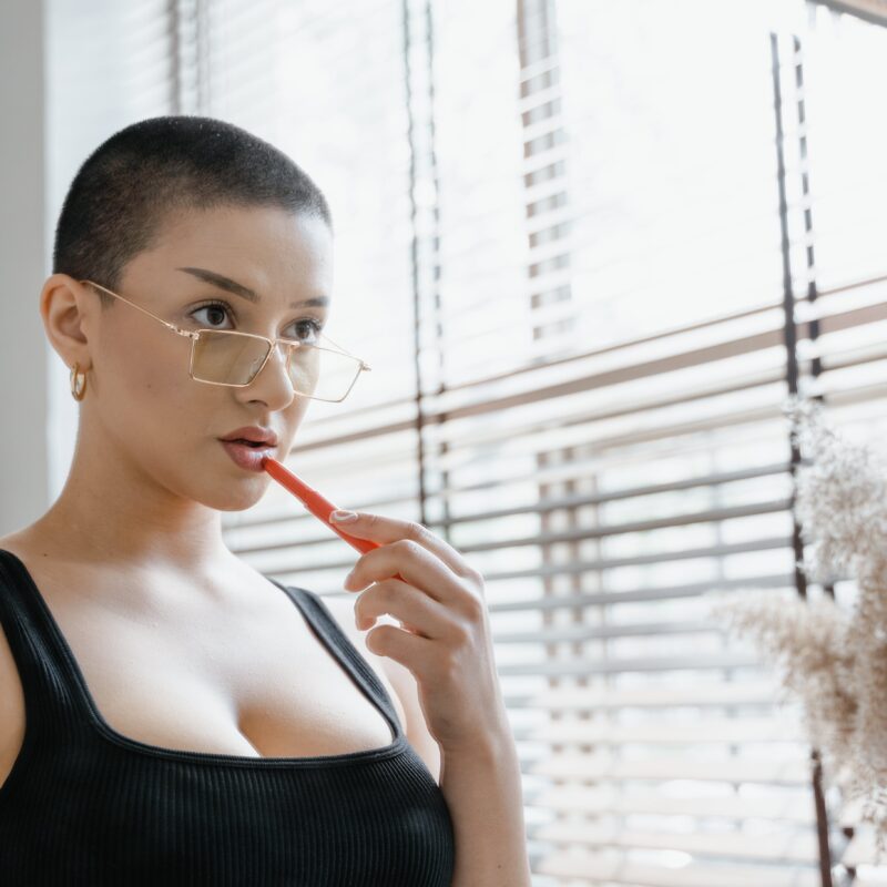 Woman in Eyeglasses Putting Lipstick