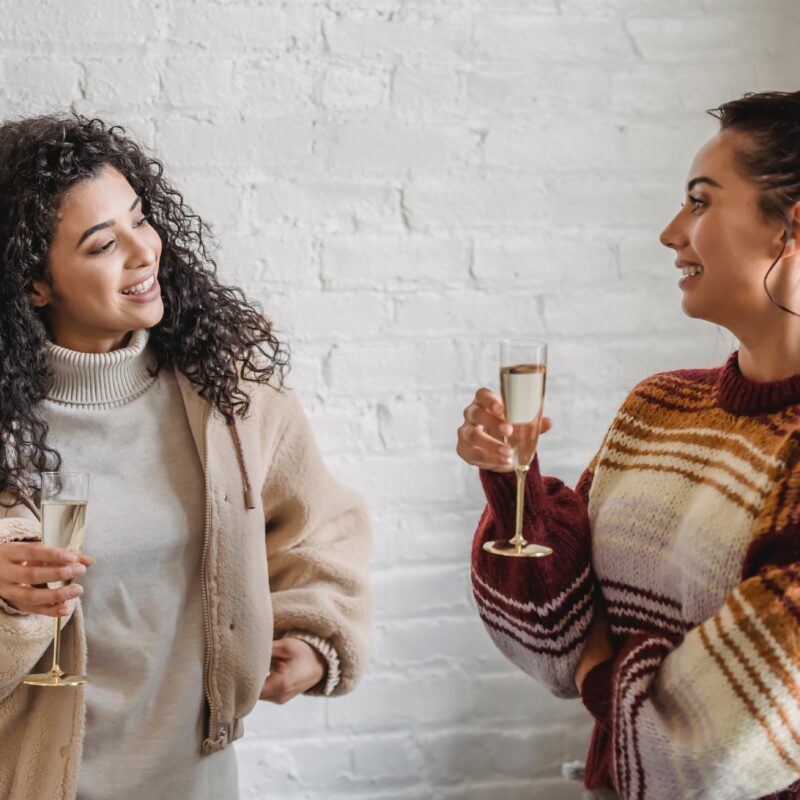 Smiling friends drinking champagne during swinger party