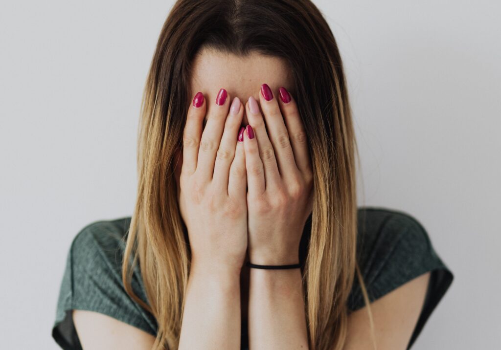 Woman in Gray Shirt Covering Her Face