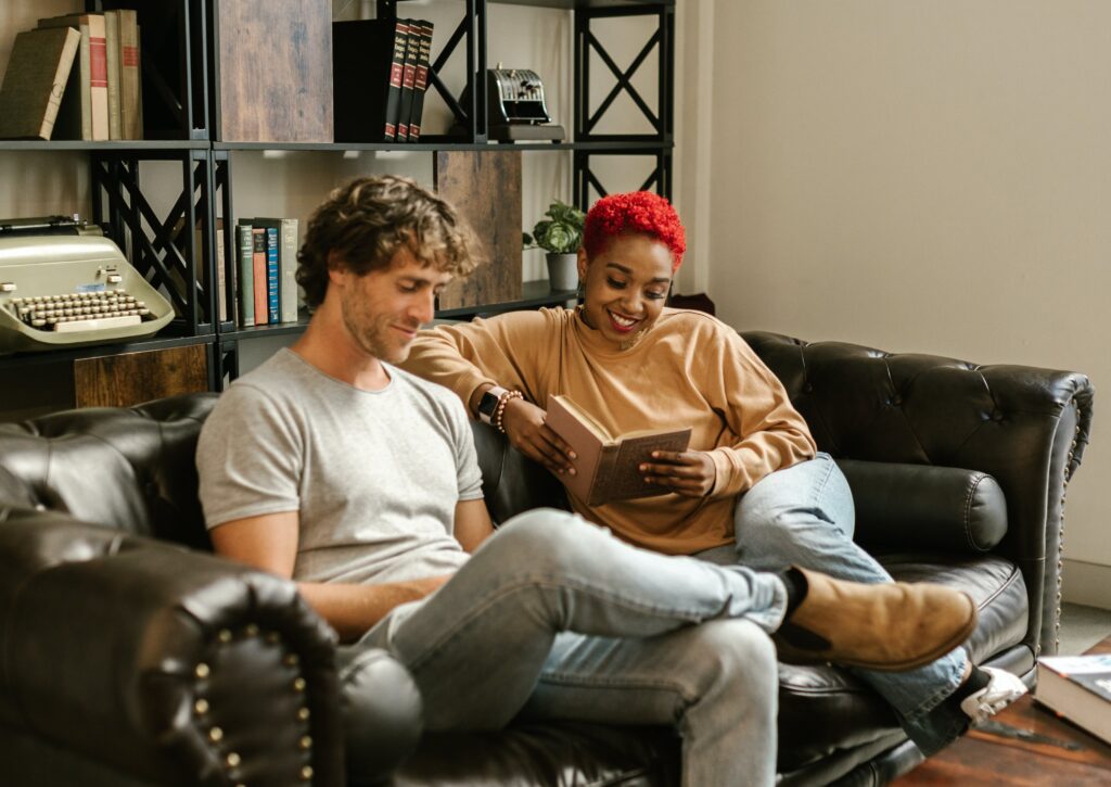 Man and Woman Sitting on Black Leather Couch