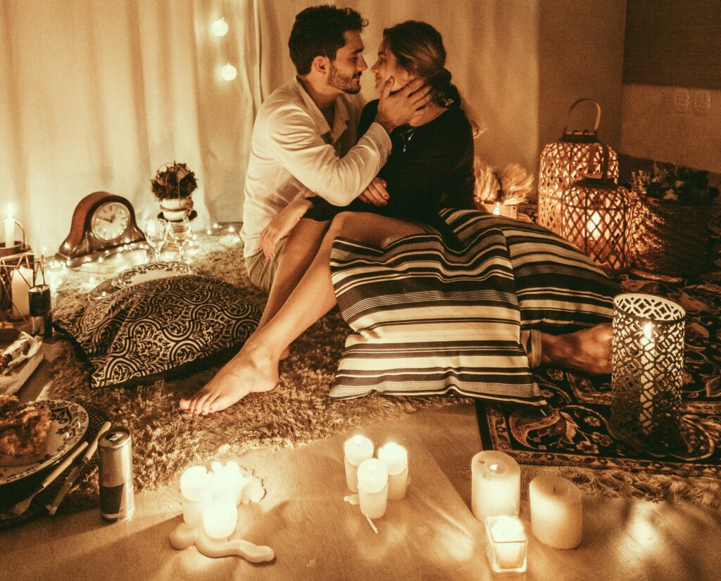 Couple about to kiss surrounded by candles