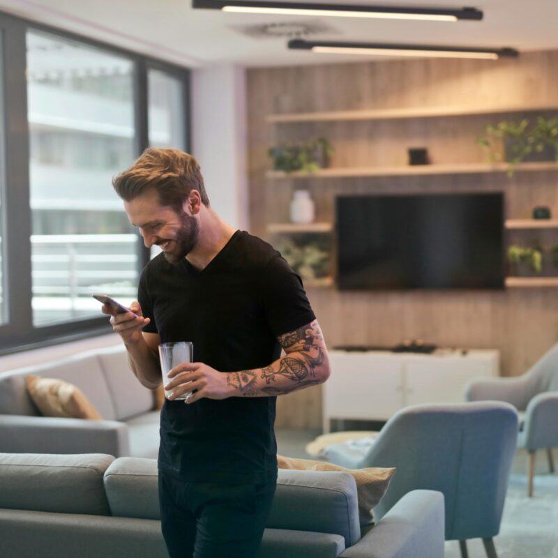 Man in Black Shirt Smiling at Sext on Phone