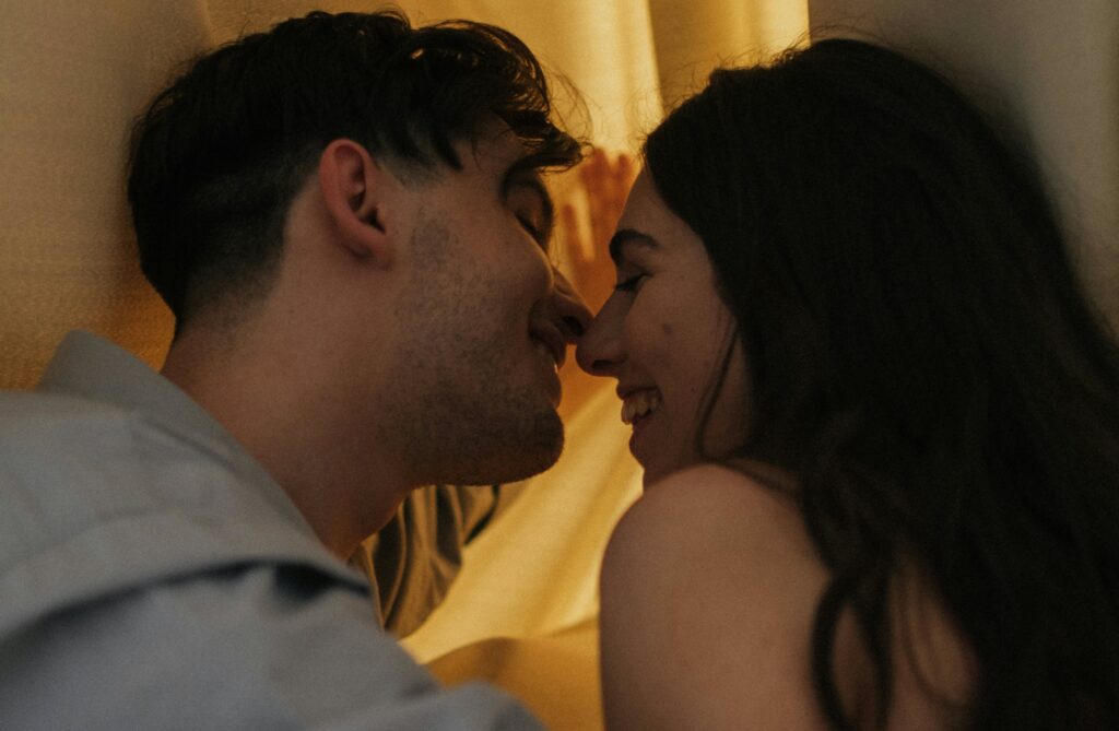 A Happy Couple Kissing Behind a Drape