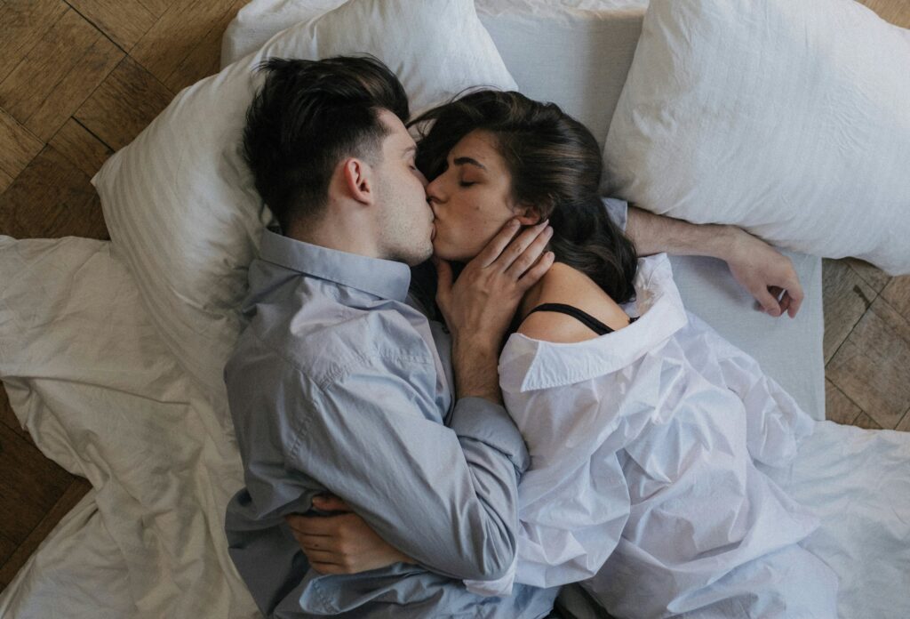Couple lying in bed and kissing
