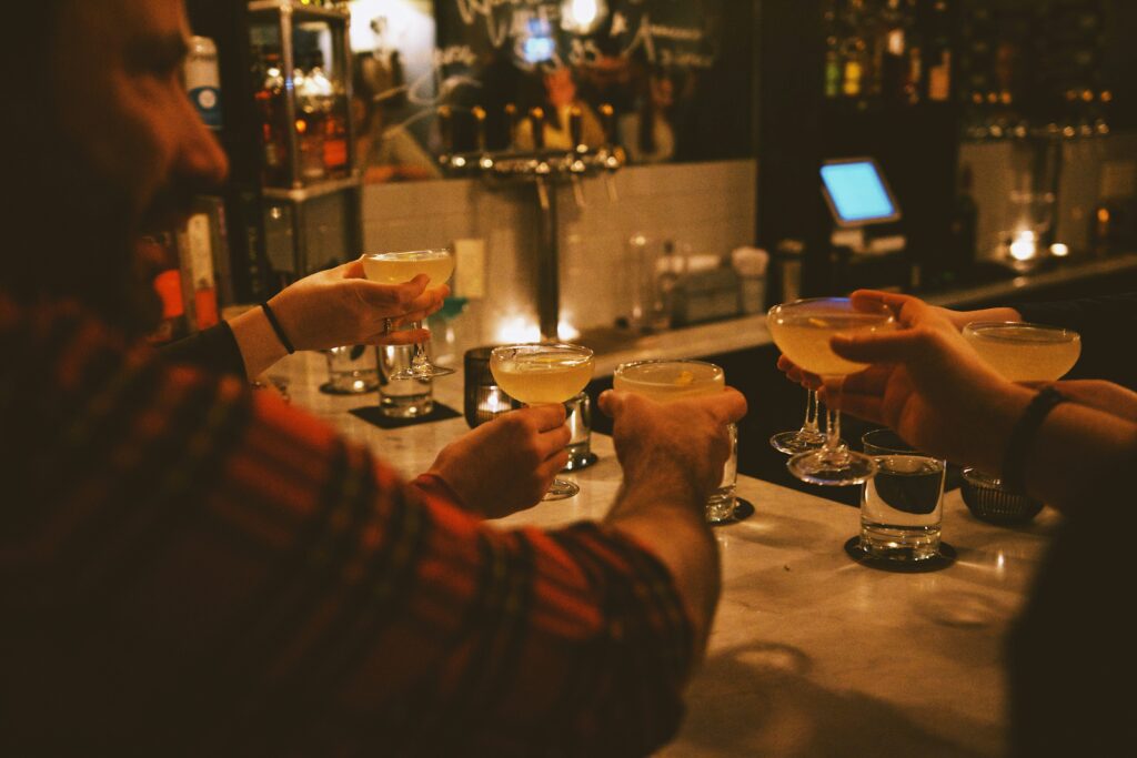 a group of people sitting at a swingers bar with drinks