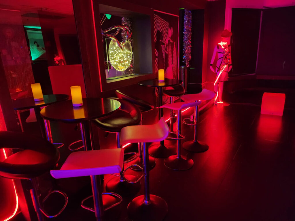 chairs, high table, mannequin in a red light room