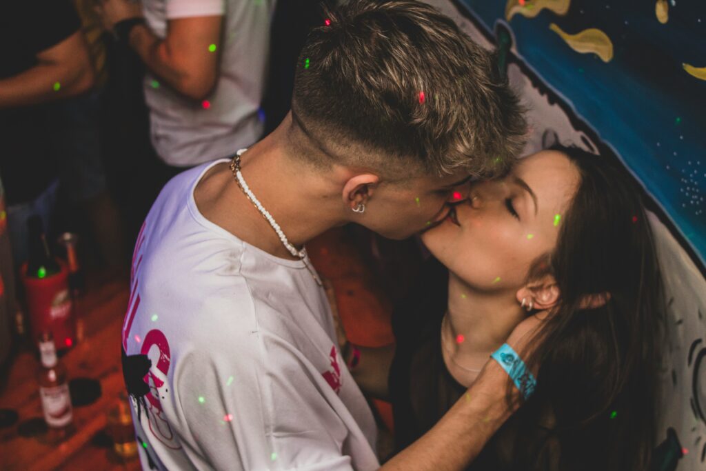 a man and a woman kissing in front of confetti