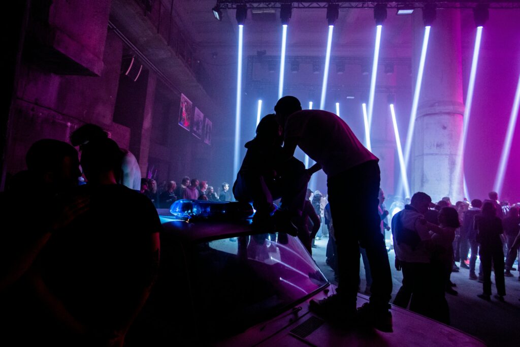 a group of people standing around in a dark room