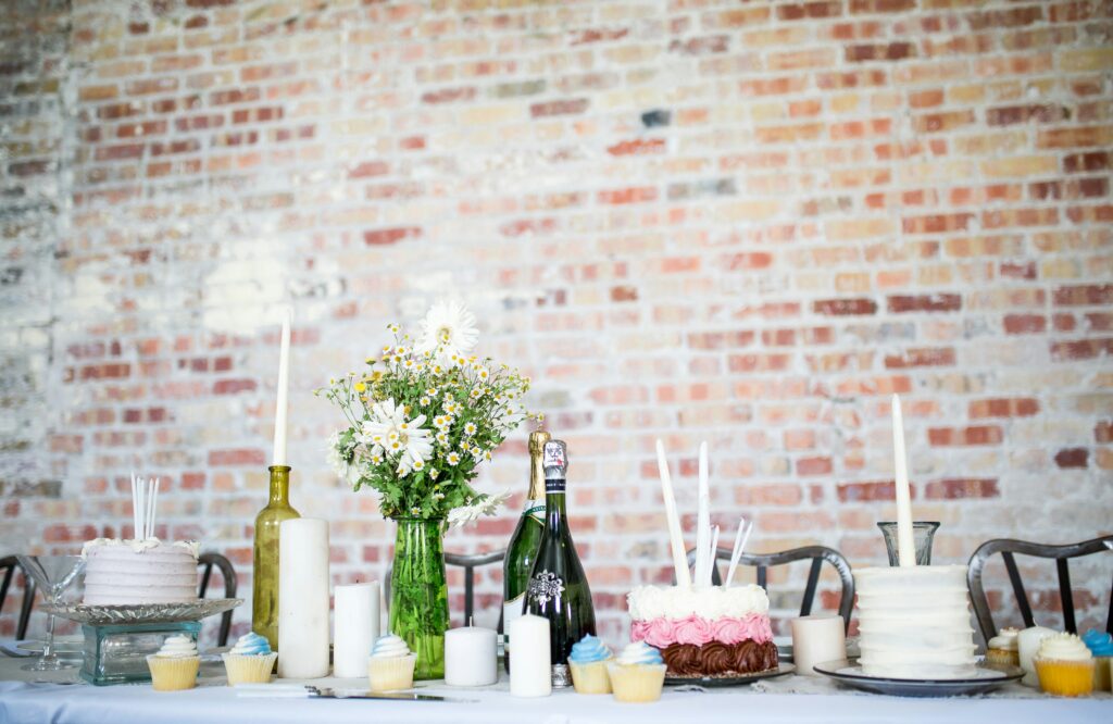 Image of wines, cakes, cupcakes in the table for a party