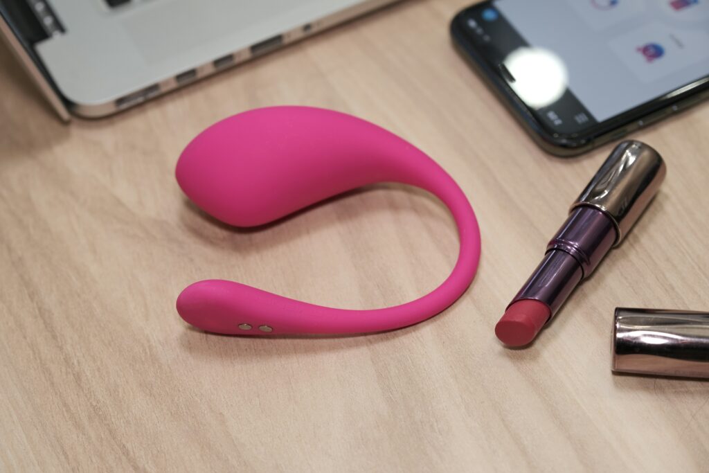 a table with a cell phone lipstick and a laptop