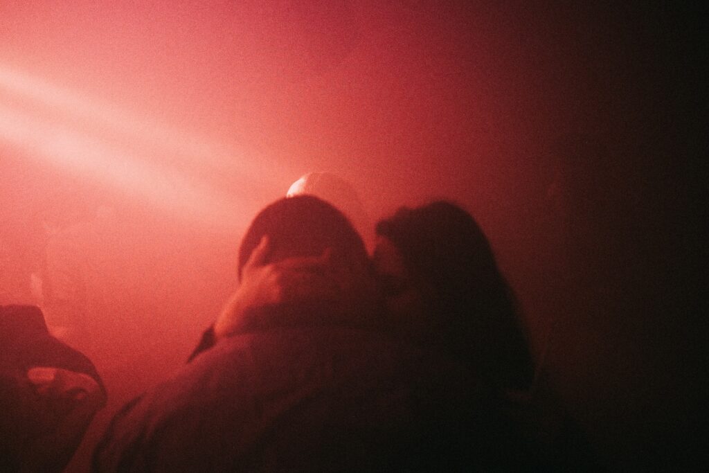 a group of people standing in front of a red light