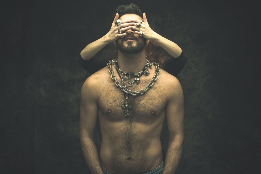 a woman with a chain on her neck and a hand on her face