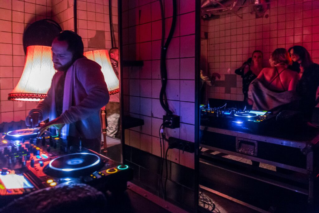 An image of a DJ and woman at the back talking