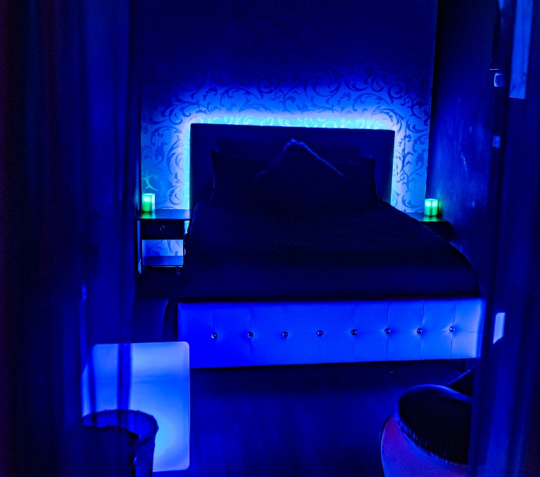 Big bedframe in the room with lights on the side