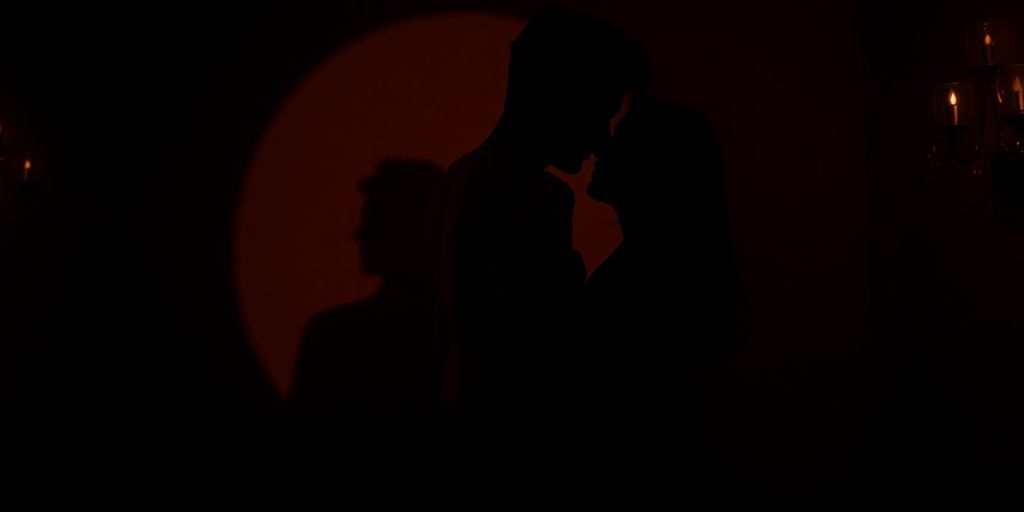 Couple in intimate embrace, shadow suggesting voyeurism