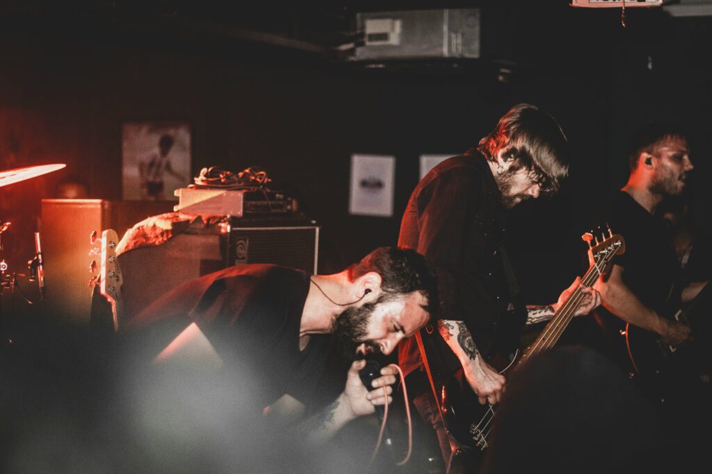 The man performing in the stage together with his band members