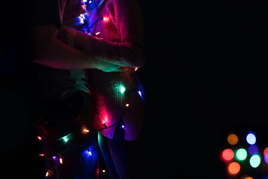 Man and woman holding each other with lights in their body