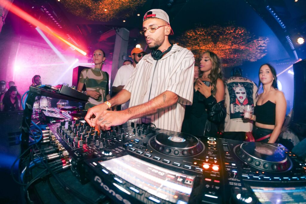 DJ are standing listening to music in the club