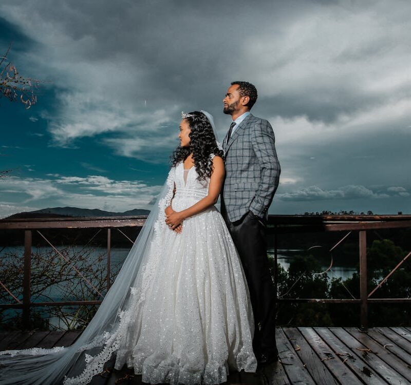 Man And Woman Standing On Brown Wooden Dock