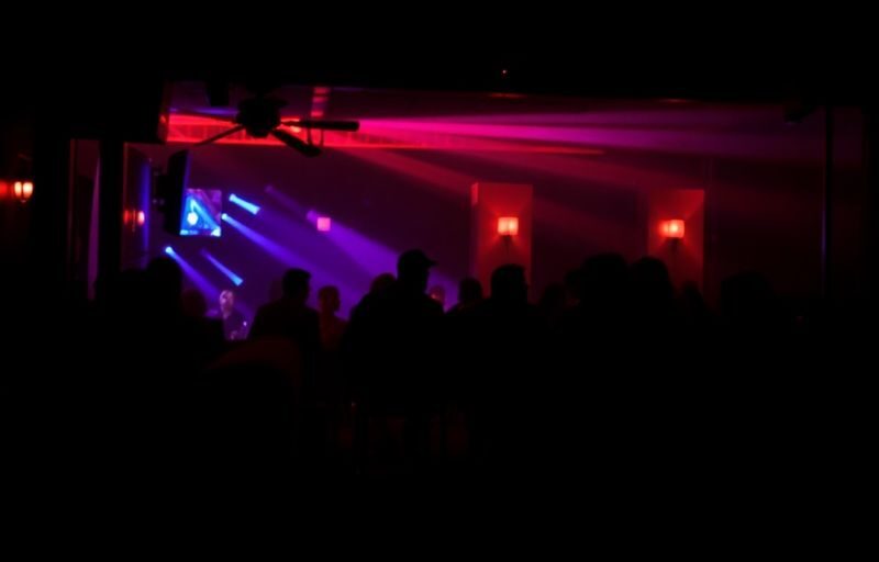 Dark, mysterious club interior, red lights, silhouettes