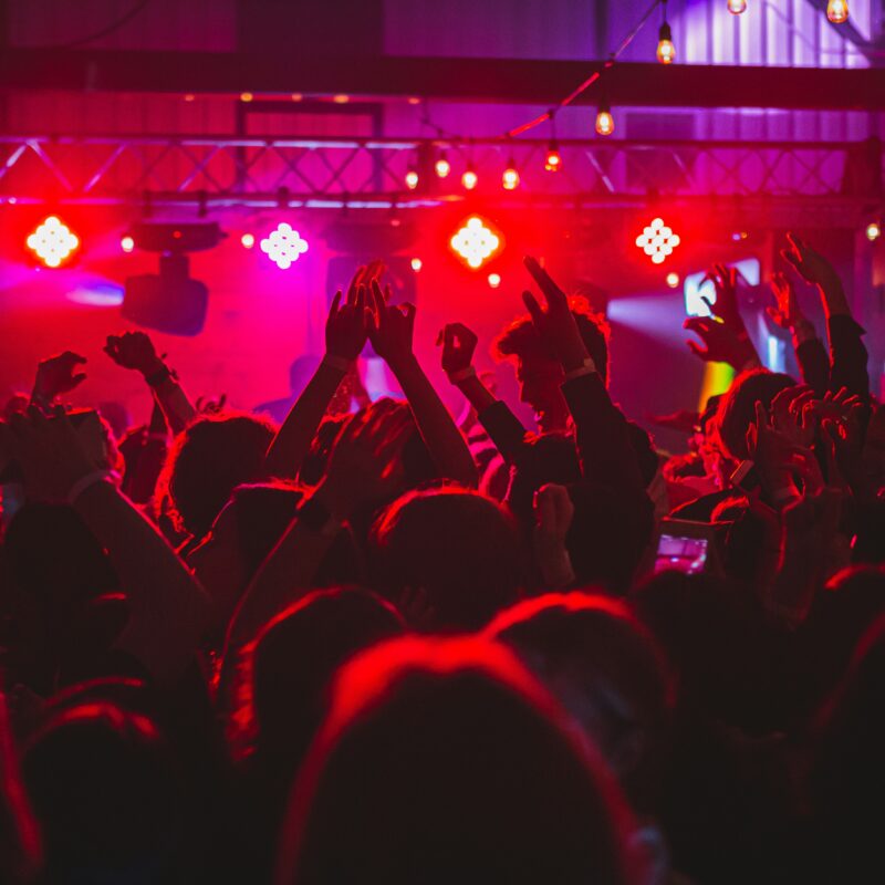 People standing on stage with lights turned on during nighttime