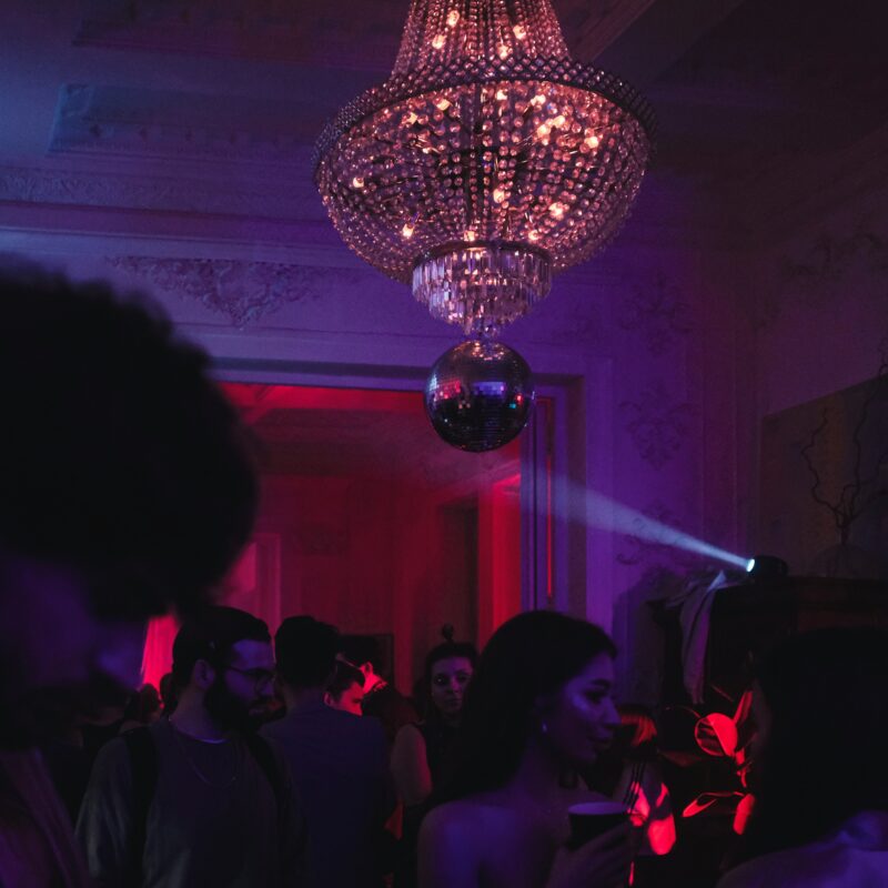 a group of people in a room with a chandelier