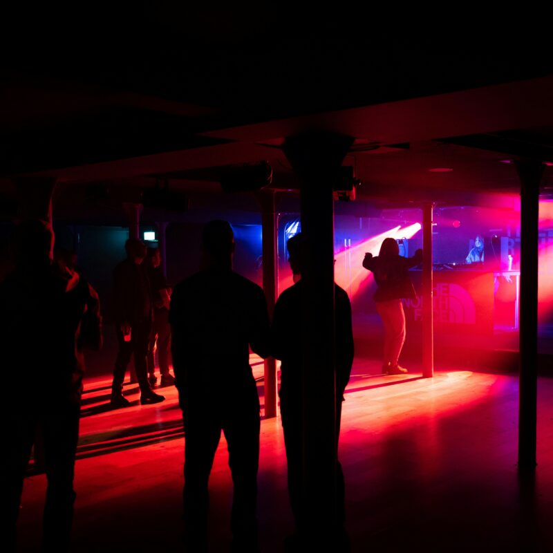 a group of people standing in a room with a red light