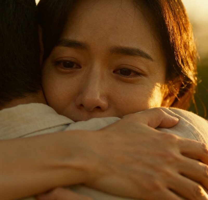 Couple embracing warmly in soft, golden light.