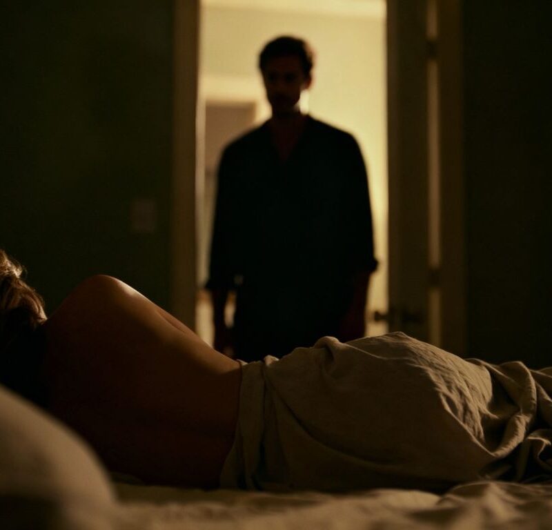 Couple in a bedroom, intimate mood.