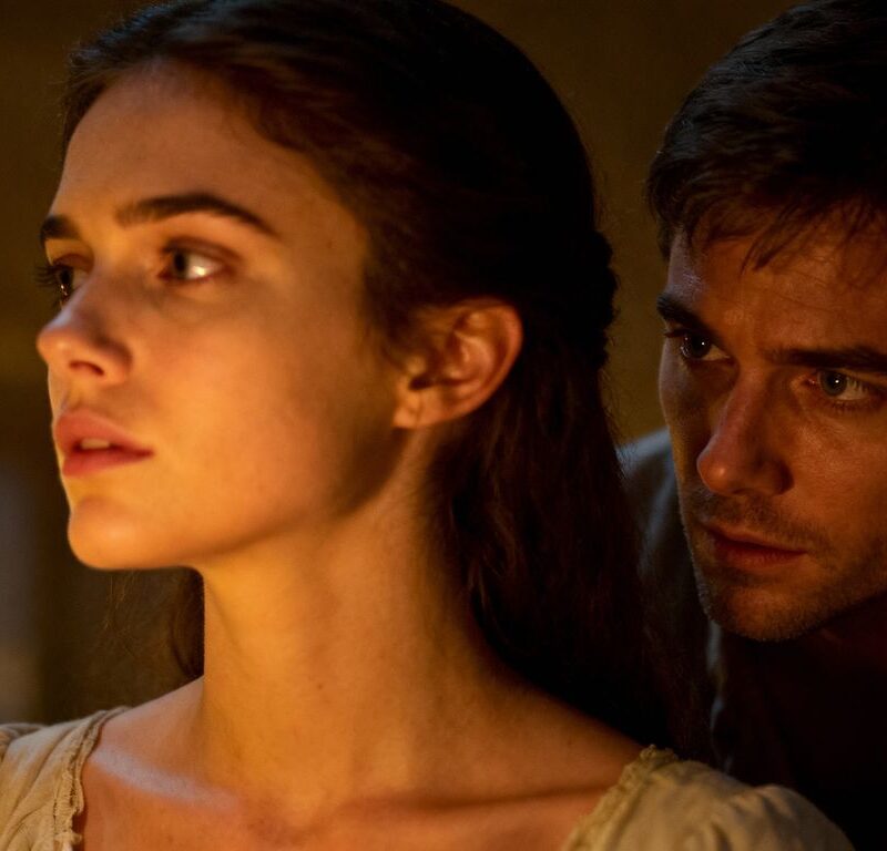 Couple in a dimly lit room, complex emotions.