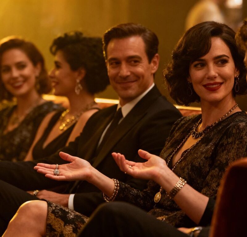 People in a lounge, subtly communicating with gestures.