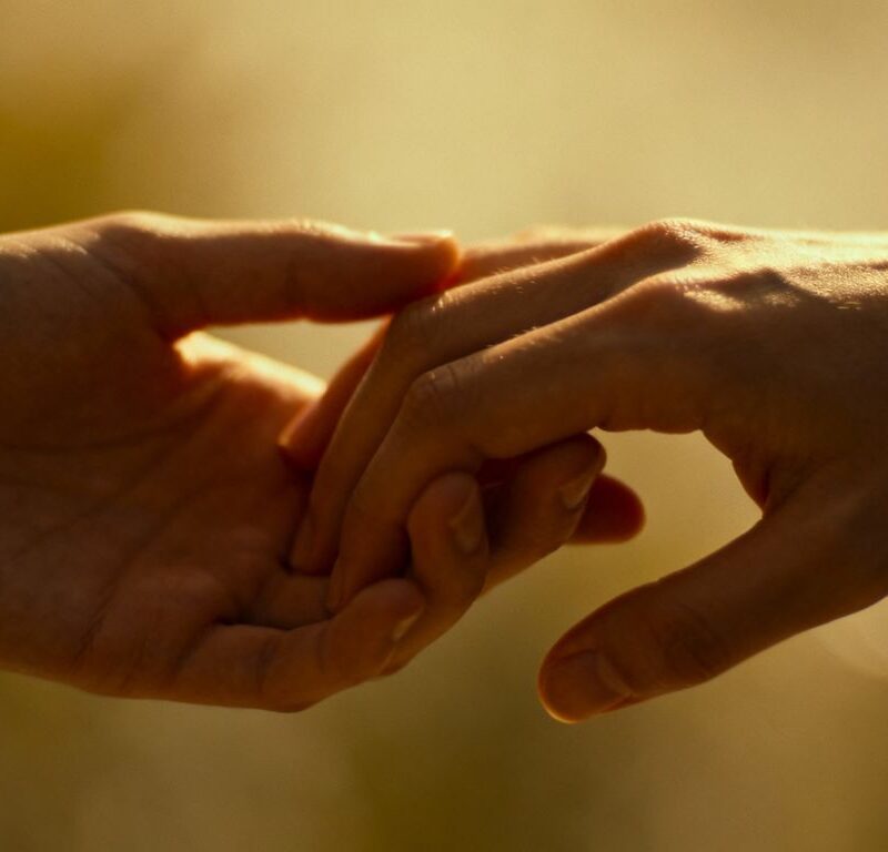 Two hands gently touching, symbolizing intimacy and connection.