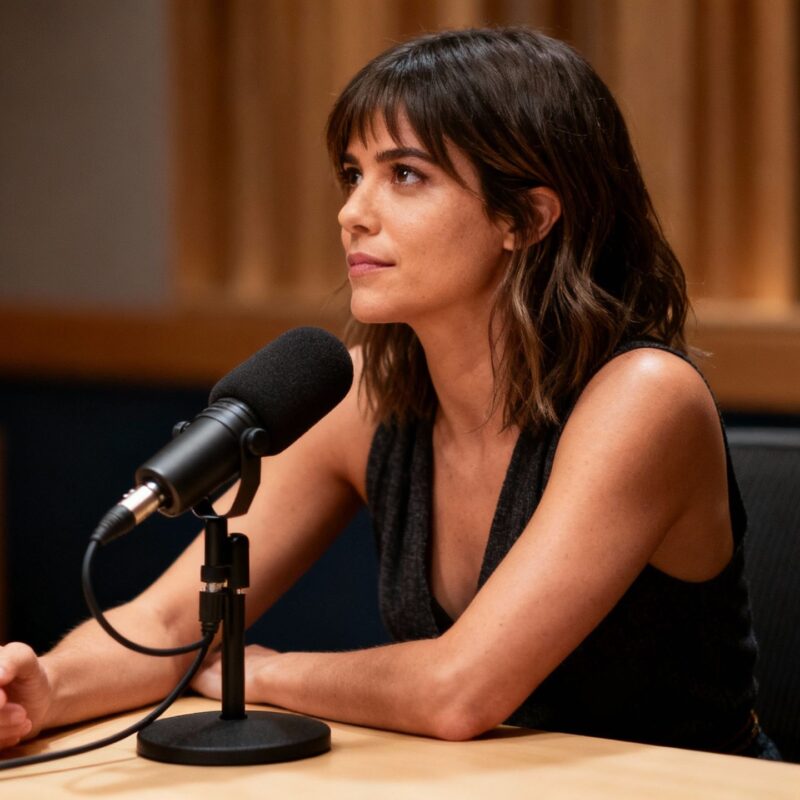 [Rachel Bilson] speaking into a podcast microphone.