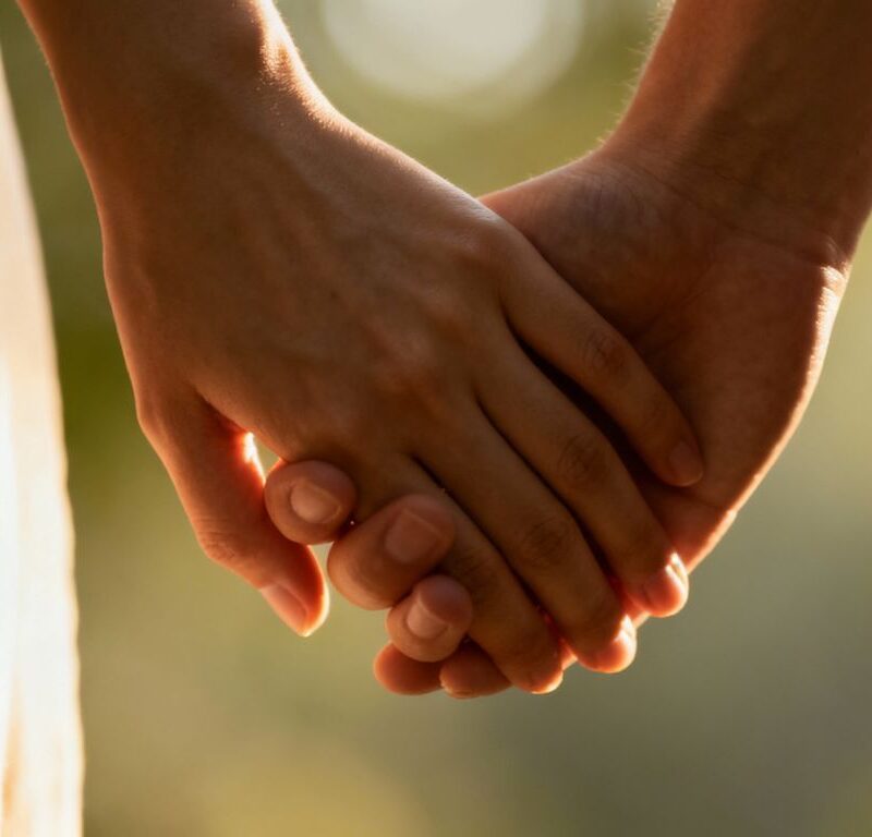 Lovers' hands intertwined, symbolizing deep trust and intimacy.