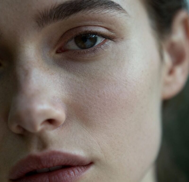 Person's face, direct gaze, soft lighting.