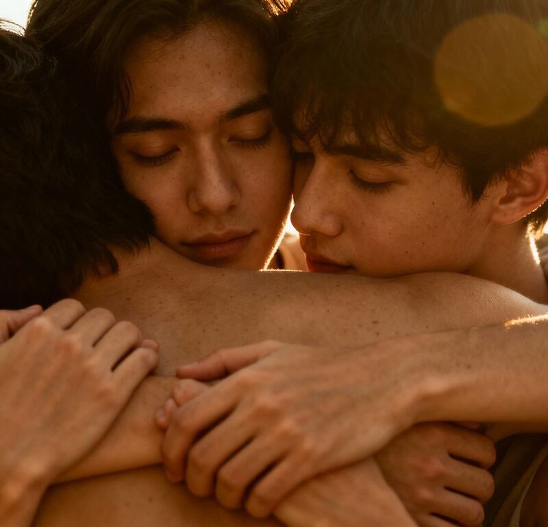 Three people in a close, affectionate embrace.