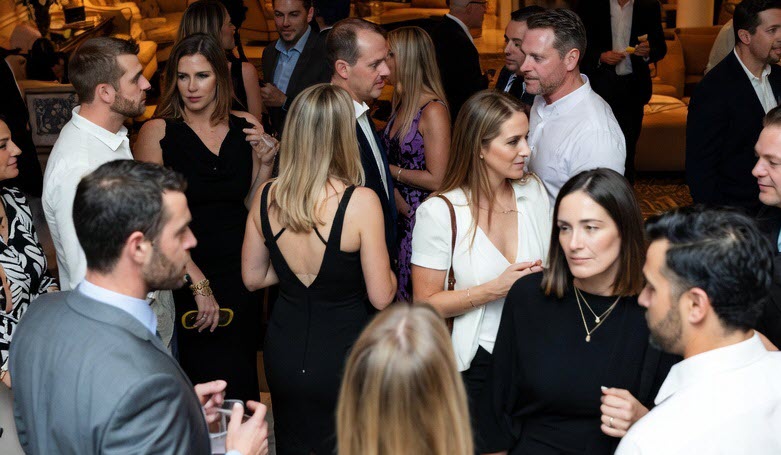 A lively crowd of well-dressed lifestyle couples socialize and flirt during an exclusive hotel takeover party in Charleston