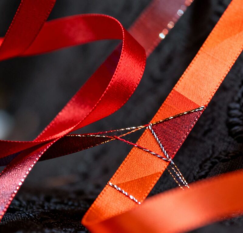 Abstract ribbons and dark fabric suggesting connection and power.