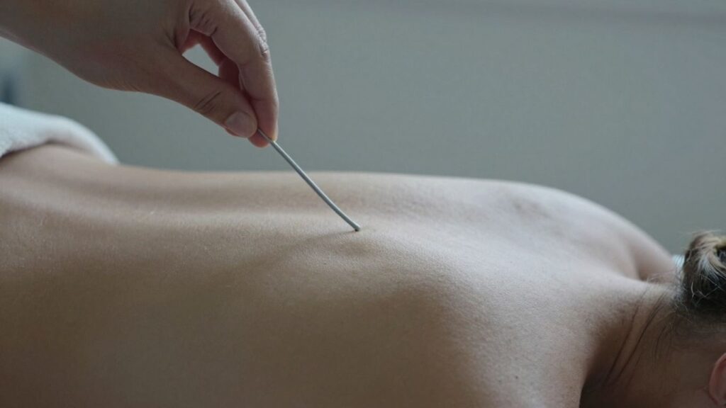 Close-up of back and hand holding a flagellation implement.