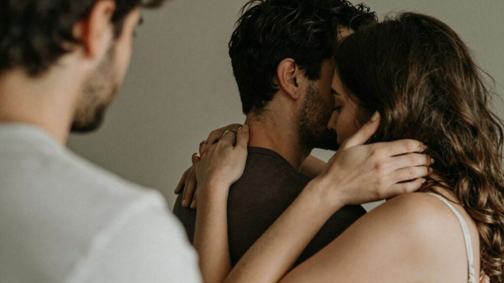 Couple and third person in intimate, complex embrace.