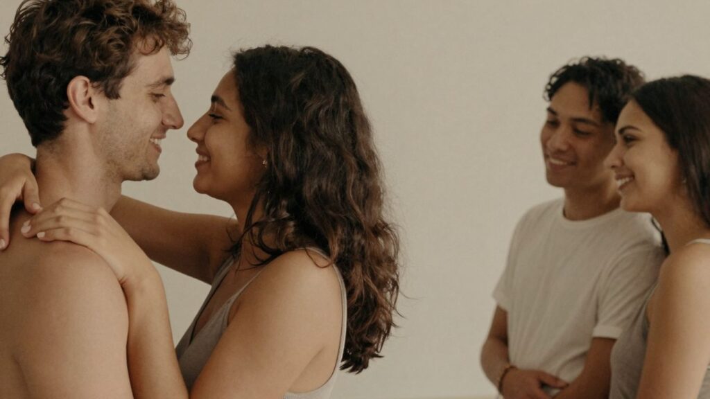 Couple embracing, another couple nearby, relaxed atmosphere.