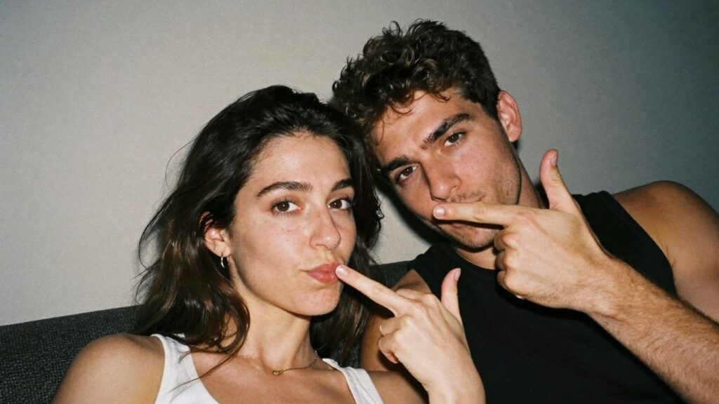 Couple in intimate setting, suggestive gesture