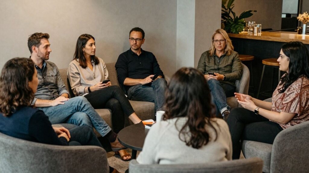 Diverse adults interacting in a comfortable, modern lounge.