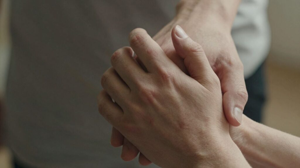 Hands gently holding after erotic flagellation.