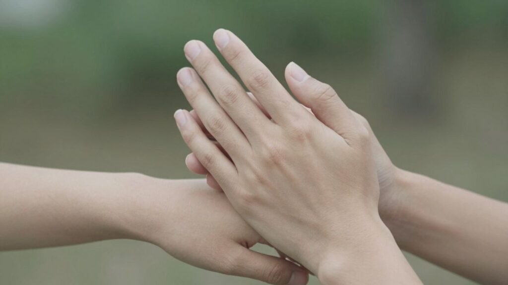 Hands gently touching, conveying trust and intimacy.